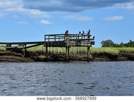 Worn Wooden Pier In The River For Fishing.