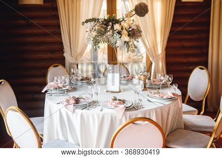 Festive Table Setting With Empty Wine Glasses And Fresh Flowers