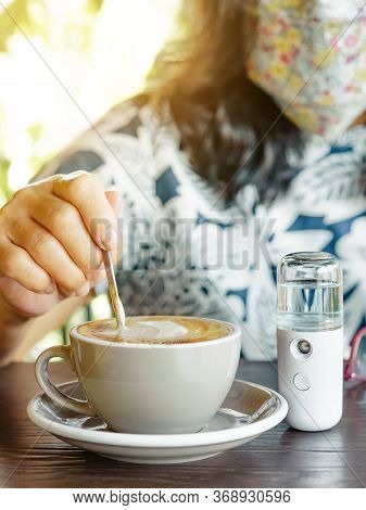 A Quarantined Woman Relax With Hot Cappuccino Coffee And Alcohol Nano Mist Sprayer On Table While Be