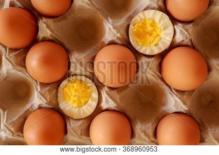 Eggs In Paper Tray. One Soft-boiled. View From Top. Boiled Halve