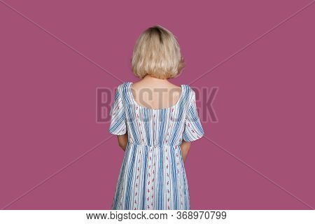 Blonde Caucasian Woman Looking To Purple Background While Wearing A Dress