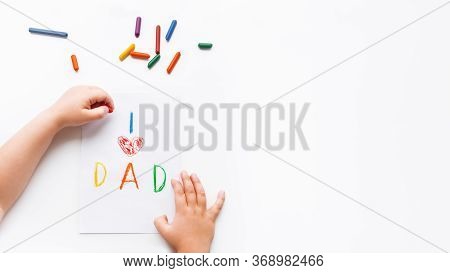 Left-handed Toddler Draws Greeting Card For Fathers Day. Kid Uses Wax Crayons To Write I Love Dad An