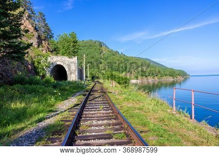 Stone Arch Tunnel In Mountain On The Circum-baikal Railway. Summer Landscape For Travel In Enigmatic
