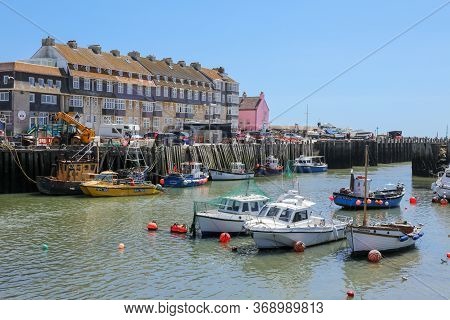 West Bay, Dorset / England - May 31,2020: A View Of The Pretty Harbour At West Bay With Pleasure Boa