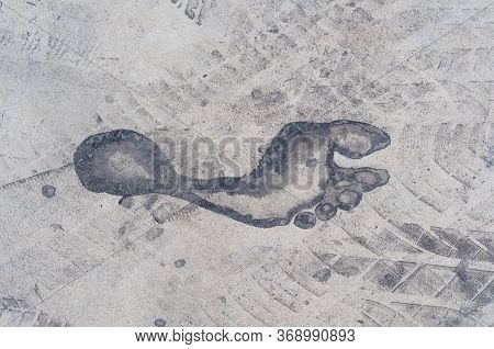 Background Texture Of A Trace Of Feet And Tires On The Asphalt. Close-up. Texture Design Of Car Tire
