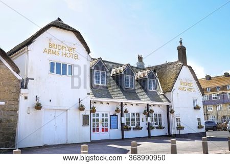 West Bay, Dorset / Uk - May 24, 2020: Facade Of The Old Inn Arms Hotel Builded In 1740