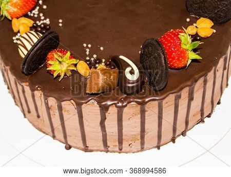 A Wonderful Sponge Cake Topped With Chocolate And Decorated With Cookies, Strawberries, Pieces Of Ch