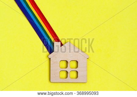 Mini Toy Wooden House And Lgbt Rainbow Ribbbon On Yellow Background