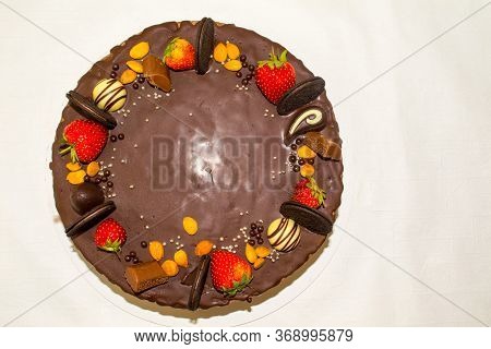 A Wonderful Sponge Cake Topped With Chocolate And Decorated With Cookies, Strawberries, Pieces Of Ch