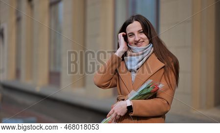 Portrait Of A Happy Girl With A Tulip On The City Street.