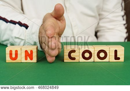A Man Separates The Cubes With The Inscription - Uncool Or Cool.