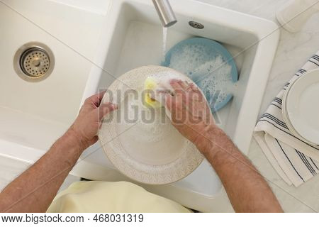 Man Washing Plate Above Sink, Top View