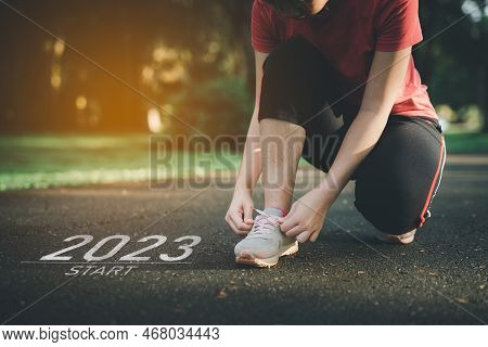 Sport Woman Runner Tie Shoelaces Start Into The New Year 2023. Start Up Of Runner Woman Running On N