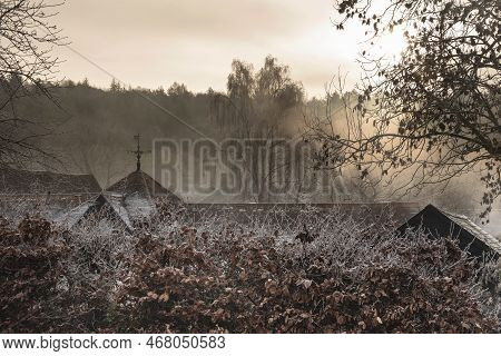 Beautiful Wintry Landscape Of Farm In Fog In English Countryside At Dawn With Hoarfrost Covering Tre