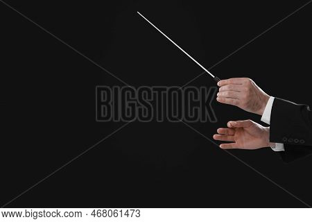 Professional Conductor With Baton On Black Background, Closeup. Space For Text
