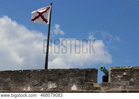 Parapet Of An Old Stone Fort Flying The Cross Of Burgundy With A Cannon Near By.
