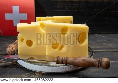 Block Of Swiss Medium-hard Yellow Cheese Emmental Or Emmentaler With Round Holes And Cheese Knife An