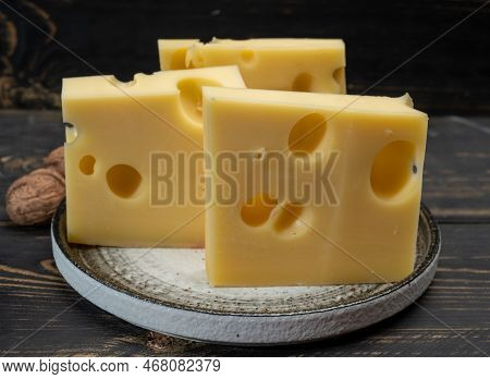 Block Of Swiss Medium-hard Yellow Cheese Emmental Or Emmentaler With Round Holes And Cheese Knife