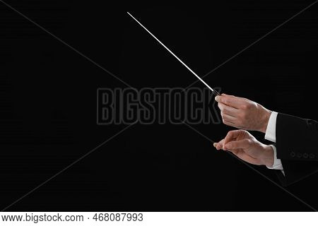Professional Conductor With Baton On Black Background, Closeup. Space For Text