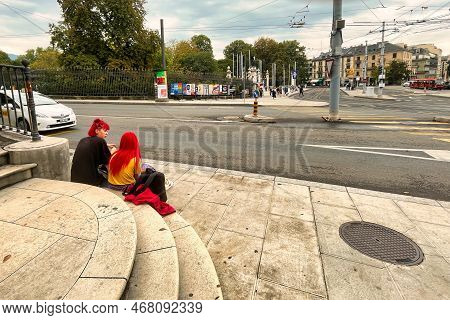 Geneva, Switzerland - September 15 2021: Two Women With Dyed Red Hair Are Sitting On Stairs On An Ur