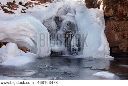 Frozen Waterfall. Mountain Water Cascades Covered With Ice