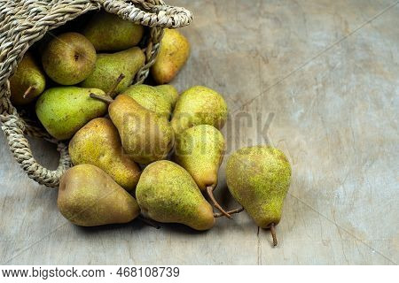 Pears In Basket On A Wooden Background. Fruit Harvest. Autumn Still Life. Pear Variety Bera Conferen