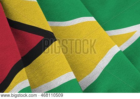 Guyana Flag With Big Folds Waving Close Up Under The Studio Light Indoors. The Official Symbols And 