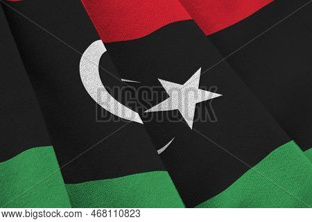 Libya Flag With Big Folds Waving Close Up Under The Studio Light Indoors. The Official Symbols And C