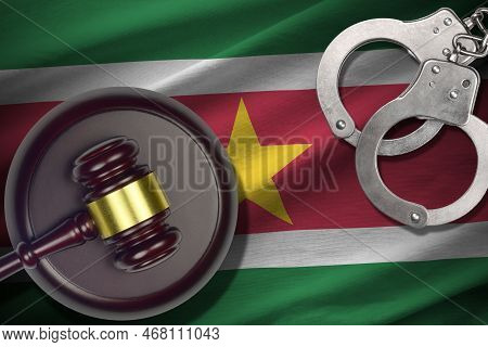 Suriname Flag With Judge Mallet And Handcuffs In Dark Room. Concept Of Criminal And Punishment, Back