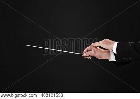 Professional Conductor With Baton On Black Background, Closeup