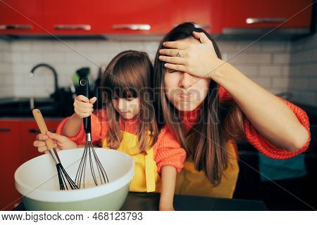 Stressed Mom Supervising Her Daughter In The Kitchen Cooking