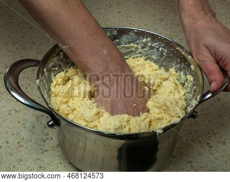 Female Hands Knead Fresh Dough For Baking Bread In An Iron Pan. Close-up Of Dough Preparation. With 