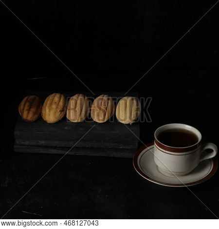 Kolombengi Cake, And A Cup Of Tea Isolated On Black Background. Indonesian Cake