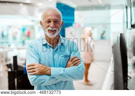 Seniors shopping appliences and gadgets in tech store.