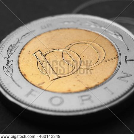 Hungarian Coin Of 100 Forints Lies On Dark Black Surface Close-up. Money Of Hungary. News About Econ