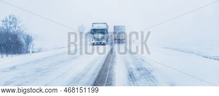 Freight Transportation Truck On The Road In Snow Storm Blizzard, Bad Weather Conditions For Transpor
