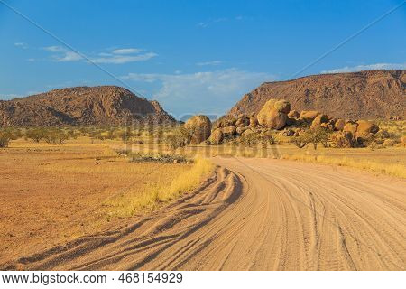 Namibian Landscape Along The Gravel Road. Red Ground And African Vegetation Around. Damaraland, Home