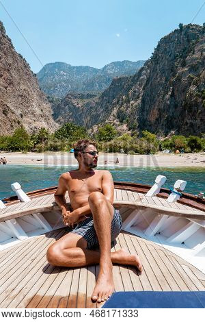 Young Man Relaxing On A Wooden Boat During A Boat Trip To Butterfly Beach At Fethiye Turkey