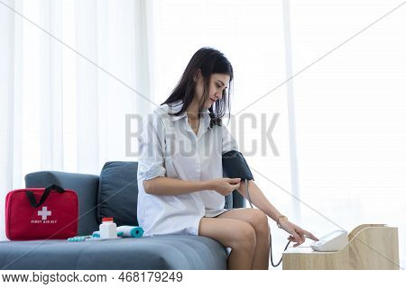 Woman Measuring Blood Pressure By Using Digital Sphygmomanometer At Home. Woman Using Medical Device