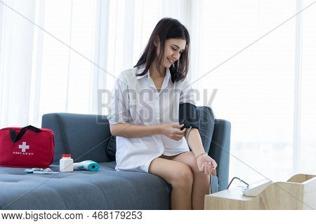 Woman Measuring Blood Pressure By Using Digital Sphygmomanometer At Home. Woman Using Medical Device