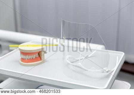 Clean Teeth Dental Jaw Model And Yellow Thooth Brush On Gray Background.