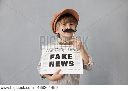 Newsboy Shouting Against Grunge Wall Background. Boy Selling Fake News