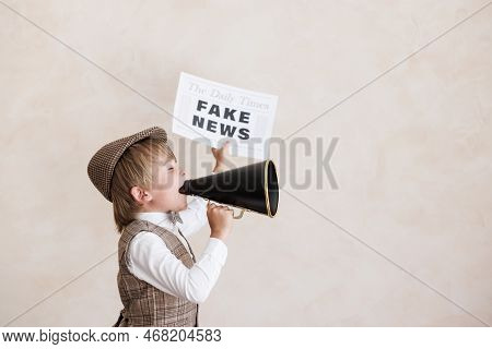 Newsboy Shouting Against Grunge Wall Background. Boy Selling Fake News