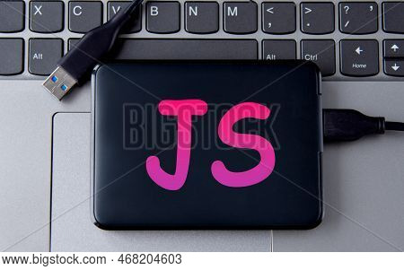 Js- Acronum On An External Drive In Gray Letters On The Background Of A Laptop. Internet Concept