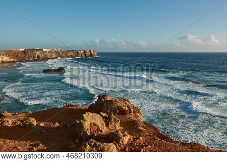 View Of The Beach Praia Do Tonel With Big Waves And Sagres Fortress In The Background. Sagres, Algar