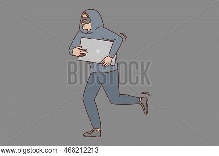Male Robber In Mask And Hood Steal Computer Running From Burglary Site. Smiling Man Burglar Or Crimi