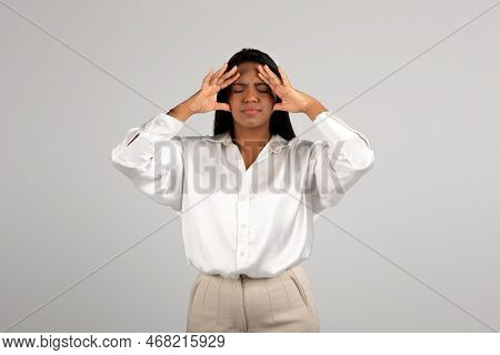 Sad Young African American Business Woman Presses Her Hands To Head Suffering From Pressure, Stress 