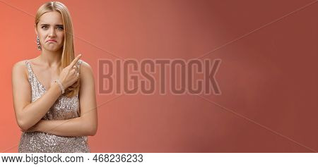 Jealous Displeased Angry Young Revengeful Blond Ex-girlfriend In Luxurious Silver Shiny Dress Frowni