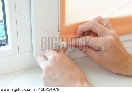 Close-up Of Male Hands Installing Roller Blinds On The Window. Installation Of Roller Blinds