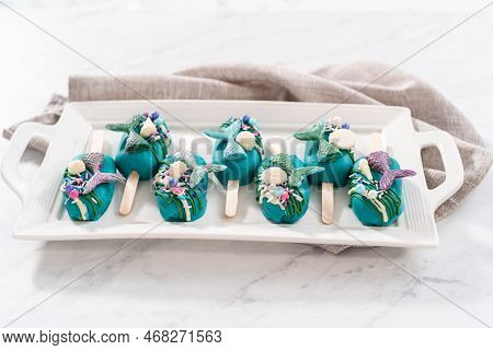 Mermaid Cakesicles With Drizzled Chocolate, Chocolate Mermaid Tails, Seashells, And Sprinkles.